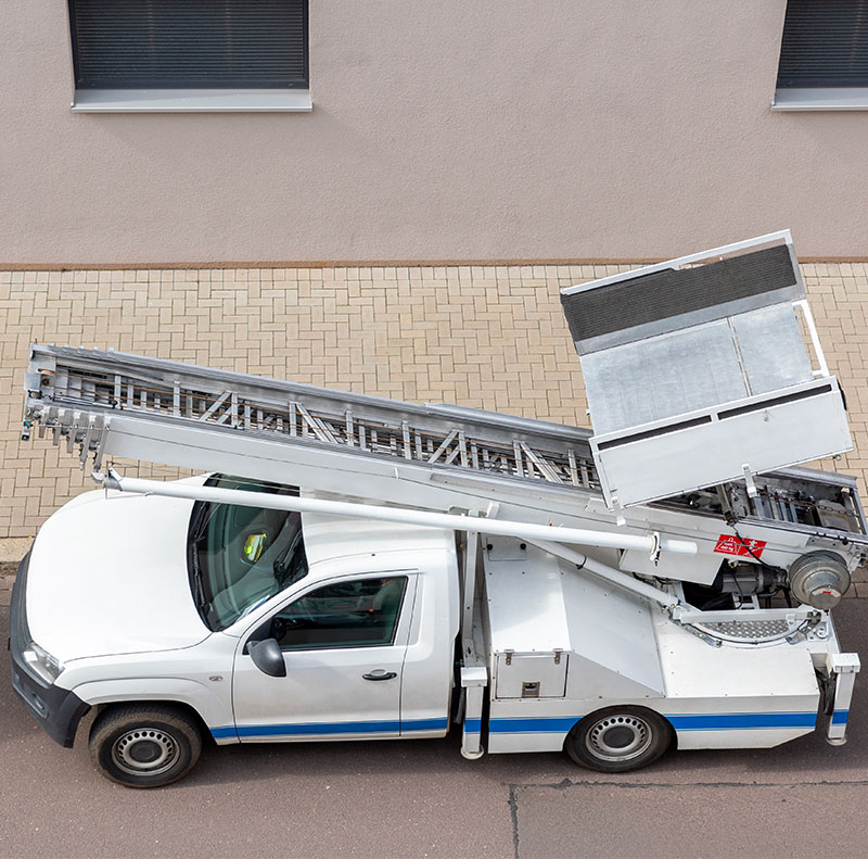 Vista dall'alto di un veicolo professionale dotato di scala aerea (autoscala), utilizzato per traslochi in appartamenti ai piani alti