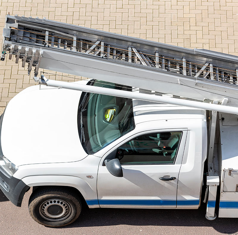Vista dall'alto di un veicolo professionale dotato di scala aerea (autoscala), utilizzato per traslochi in appartamenti ai piani alti